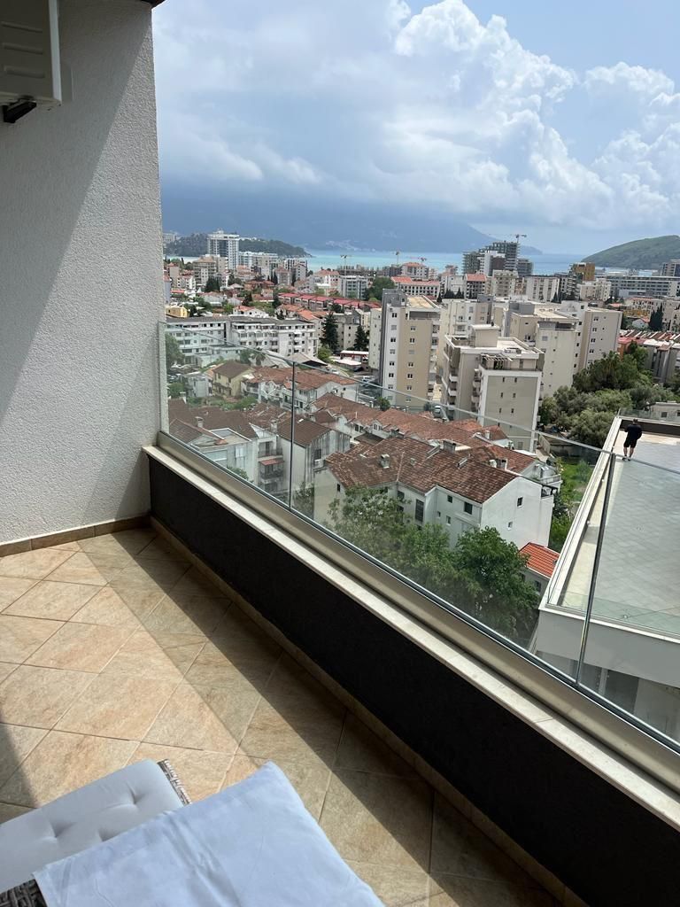 faa79058-96e2-4dc8-afc4-289379739f16 Dnevni boravak jednosobnog stana u Budvi sa plavom garniturom i izlazom na balkon – fotografija 8
