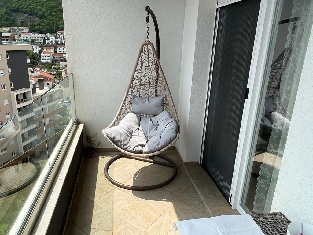 f70ab68a-3274-4bae-8056-c66ae8ee59d1 Dnevni boravak jednosobnog stana u Budvi sa plavom garniturom i izlazom na balkon – fotografija 9
