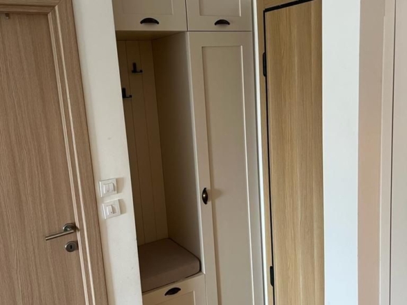 Dnevni boravak jednosobnog stana u Budvi sa plavom garniturom i izlazom na balkon – fotografija 15