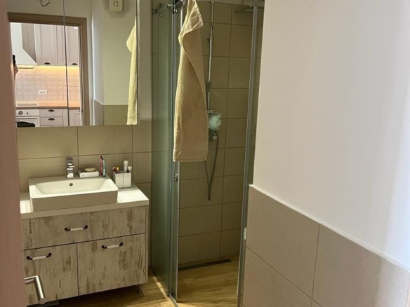 Dnevni boravak jednosobnog stana u Budvi sa plavom garniturom i izlazom na balkon – fotografija 18