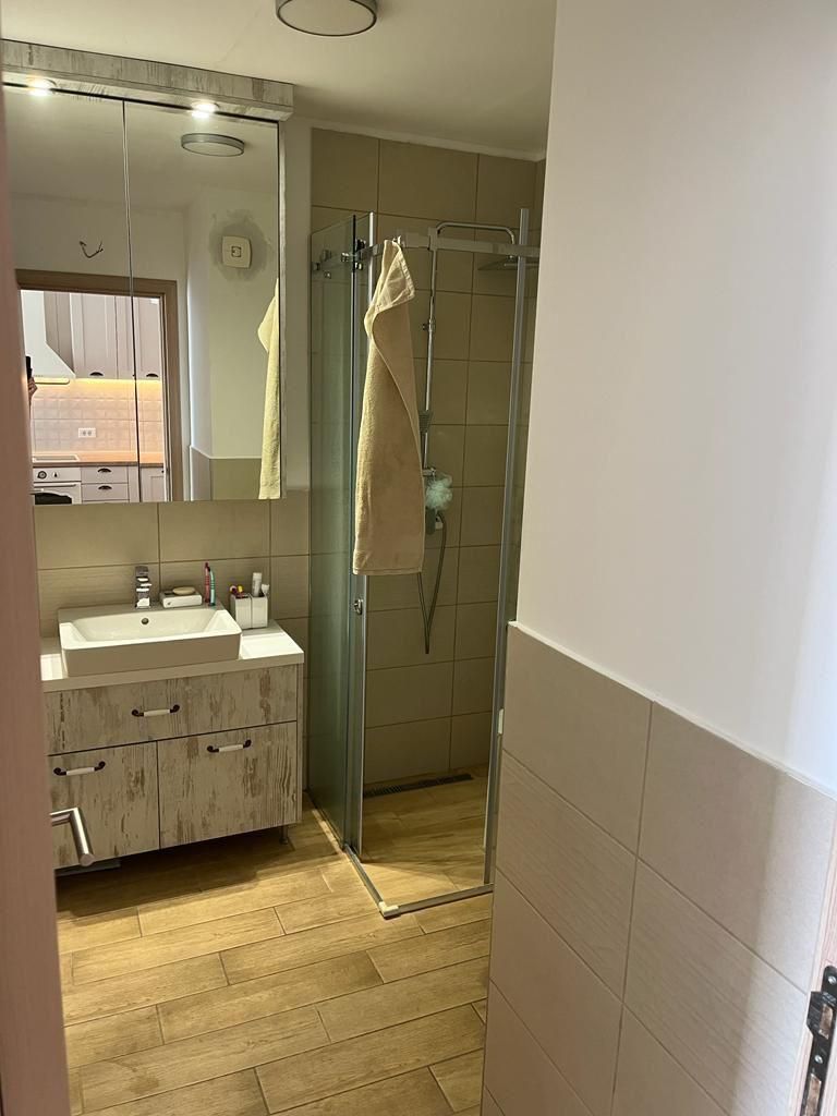 73477fed-1c37-4cd5-9515-819dcb8f4225 Dnevni boravak jednosobnog stana u Budvi sa plavom garniturom i izlazom na balkon – fotografija 18